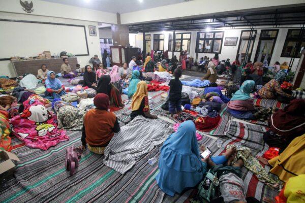 Villagers rest as they shelter at a district office after being evacuated following the eruption of Mount Semeru volcano in Lumajang, East Java Province, Indonesia, on Dec. 4, 2022. (Antara Foto/Umarul Faruq/via Reuters)