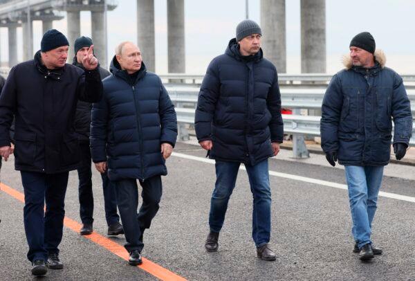 Russian President Vladimir Putin, (3rd R), listens to Deputy Prime Minister Marat Khusnullin, (L), as he visits the Crimean Bridge connecting Russian mainland and Crimean peninsula over the Kerch Strait, which was damaged by a truck bomb attack in October, after restoration works, not far from Kerch, Crimea, on Dec. 5, 2022. (Mikhail Metzel, Sputnik, Kremlin Pool Photo via AP)