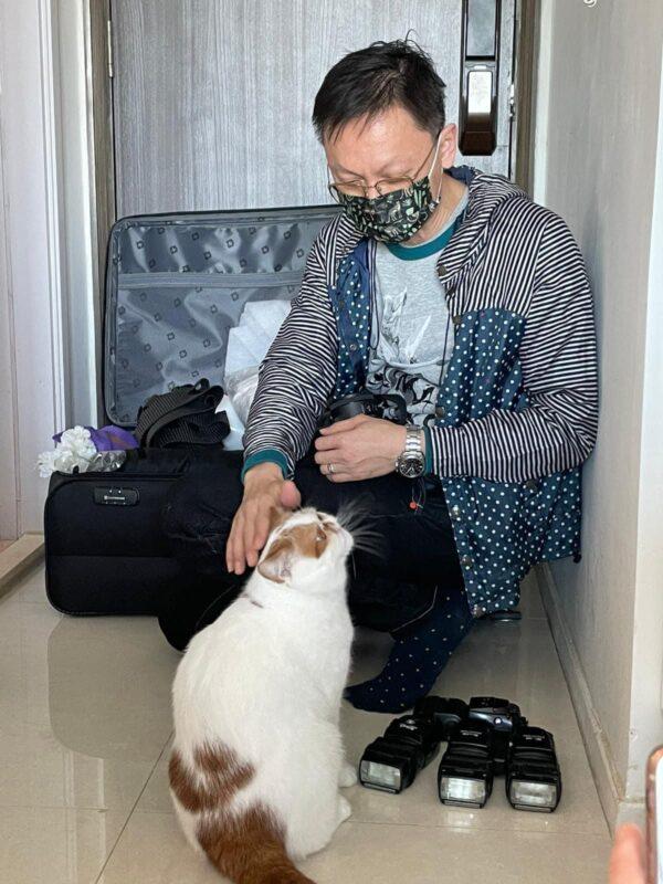Wilson pets a cat he will photograph. (Courtesy of Wilson Ng)