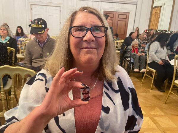 Kathleen York holds her dog tag commemorating her late son in law, Patrick Wade at Nixon Library’s Hometown Heroes ceremony in Yorba Linda, Calif., on Dec. 4, 2022. (Carol Cassis/The Epoch Times)