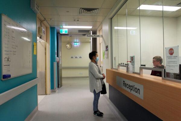 A patient registers with administration staff at St George Hospital in Sydney, Australia, on May 15, 2020. (Lisa Maree Williams/Getty Images)