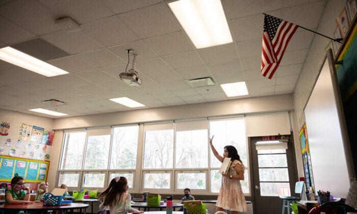 A teacher gestures to her class of mask-wearing students at Medora Elementary School in Louisville, Ky. on March 17, 2021. (Jon Cherry/Getty Images)
