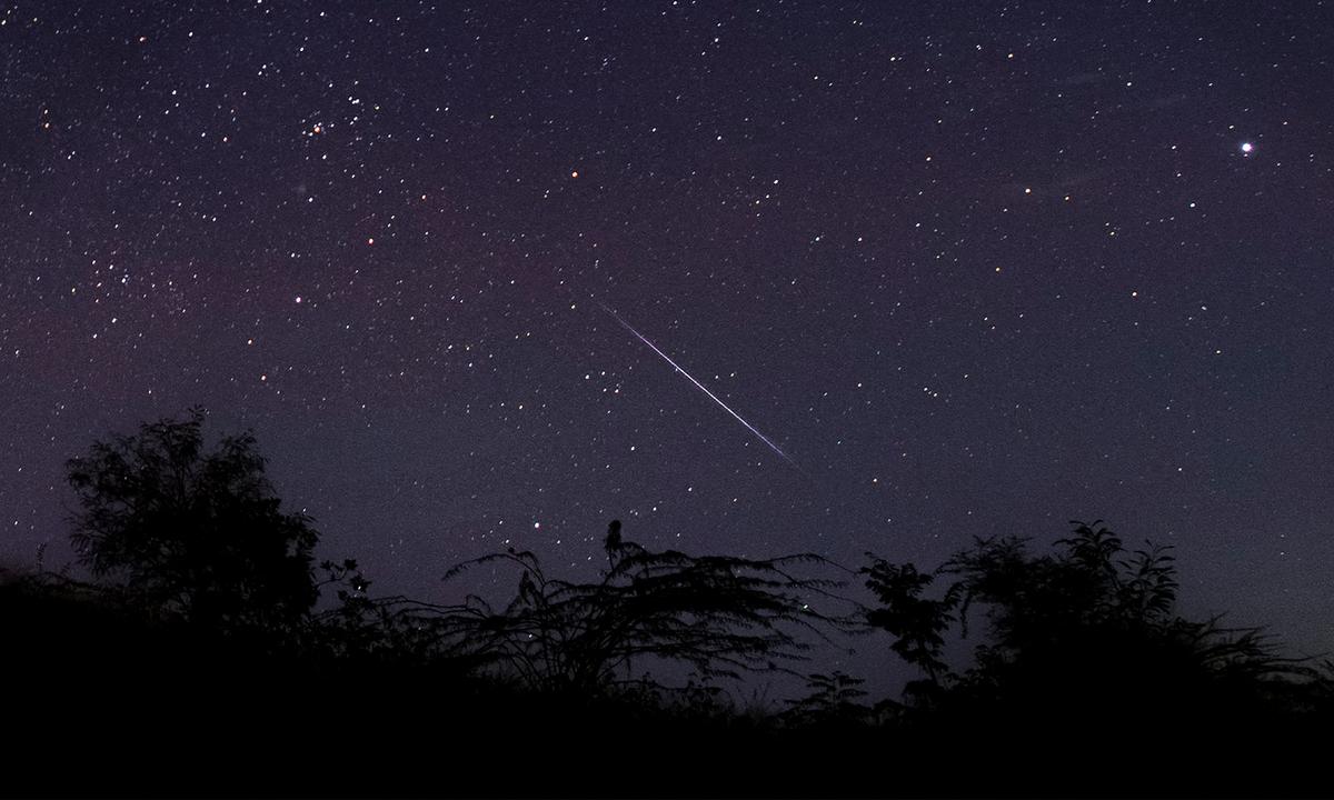 A long exposure shows a meteor streaking through the night sky over Myanmar during the Geminid meteor shower near Mandalay city. (YE AUNG THU/Getty Images)