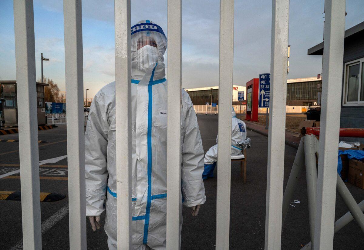An epidemic control worker guards the gate of a government quarantine facility in Beijing on Dec. 7, 2022. (Kevin Frayer/Getty Images)