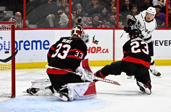Los Angeles Kings defenseman Mikey Anderson scores on Ottawa Senators goaltender Cam Talbot (33) as defenseman Travis Hamonic (23) attempts to block a shot, during the first period of an NHL hockey game, in Ottawa, Ontario, Dec. 6, 2022. (Justin Tang/The Canadian Press via AP)