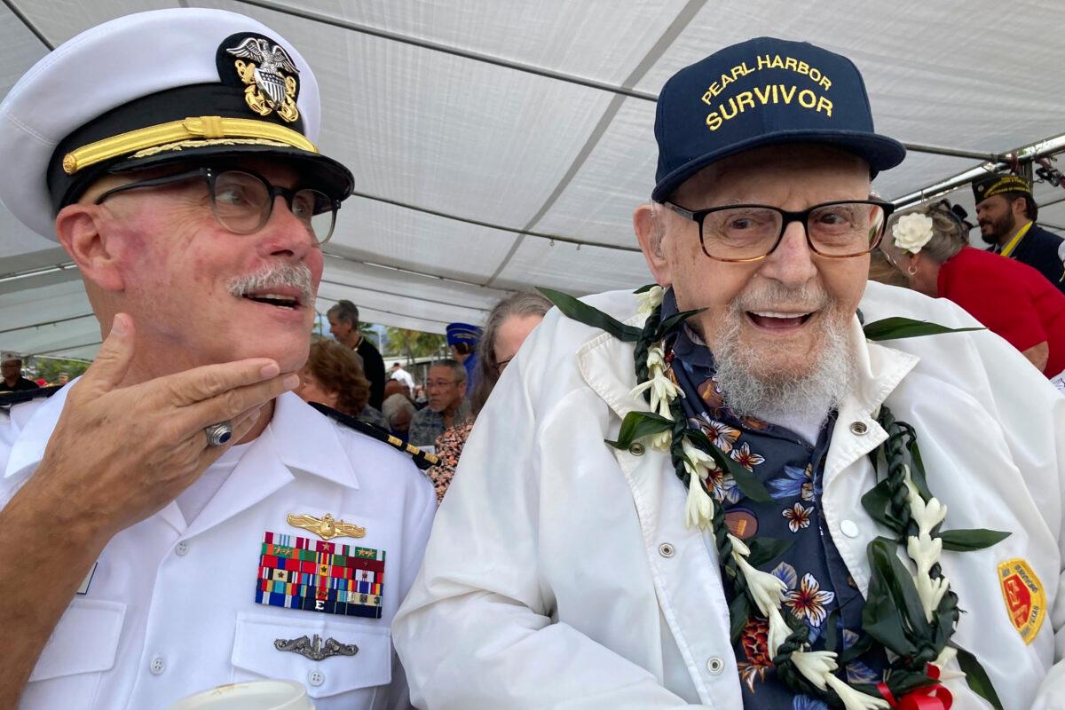 Ira Schab (R), 102, who survived the attack on Pearl Harbor as a sailor on the USS Dobbin, talks with reporters while sitting next to his son, retired Navy Cmdr. Karl Schab, in Pearl Harbor, Hawaii, on Dec. 7, 2022. (Audrey McAvoy/AP Photo)