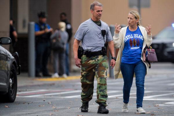 A police officer speaks to a woman outside a Walmart store in Kennesaw, Ga., on Dec. 7, 2022. (Mike Stewart/AP Photo)