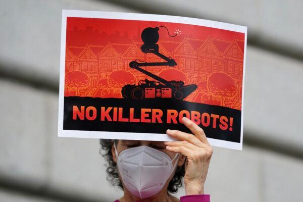A woman holds up a sign while taking part in a demonstration about the use of robots by the San Francisco Police Department outside of City Hall in San Francisco, on Dec. 5, 2022. (Jeff Chiu/AP Photo)