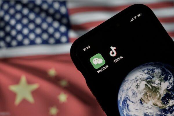 A mobile phone can be seen displaying the logos for Chinese apps WeChat and TikTok in front of a monitor showing the flags of the United States and China on an internet page, in Beijing, on Sept. 22, 2020. (Kevin Frayer/Getty Images)