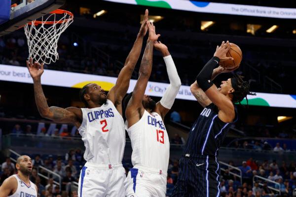 Orlando Magic forward Paolo Banchero shoots over Los Angeles Clippers forward Kawhi Leonard (2) and guard Paul George (13) during the first half of an NBA basketball game in Orlando, Fla., on Dec. 7, 2022. (Scott Audette/AP Photo)