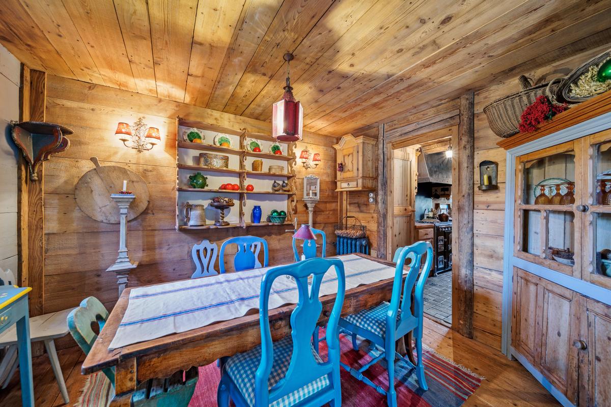 The dining room is conveniently located adjacent to the kitchen. Generous use of wood on all surfaces creates a relaxing, traditional ambiance. (Courtesy of Sotheby’s Concierge Auctions)