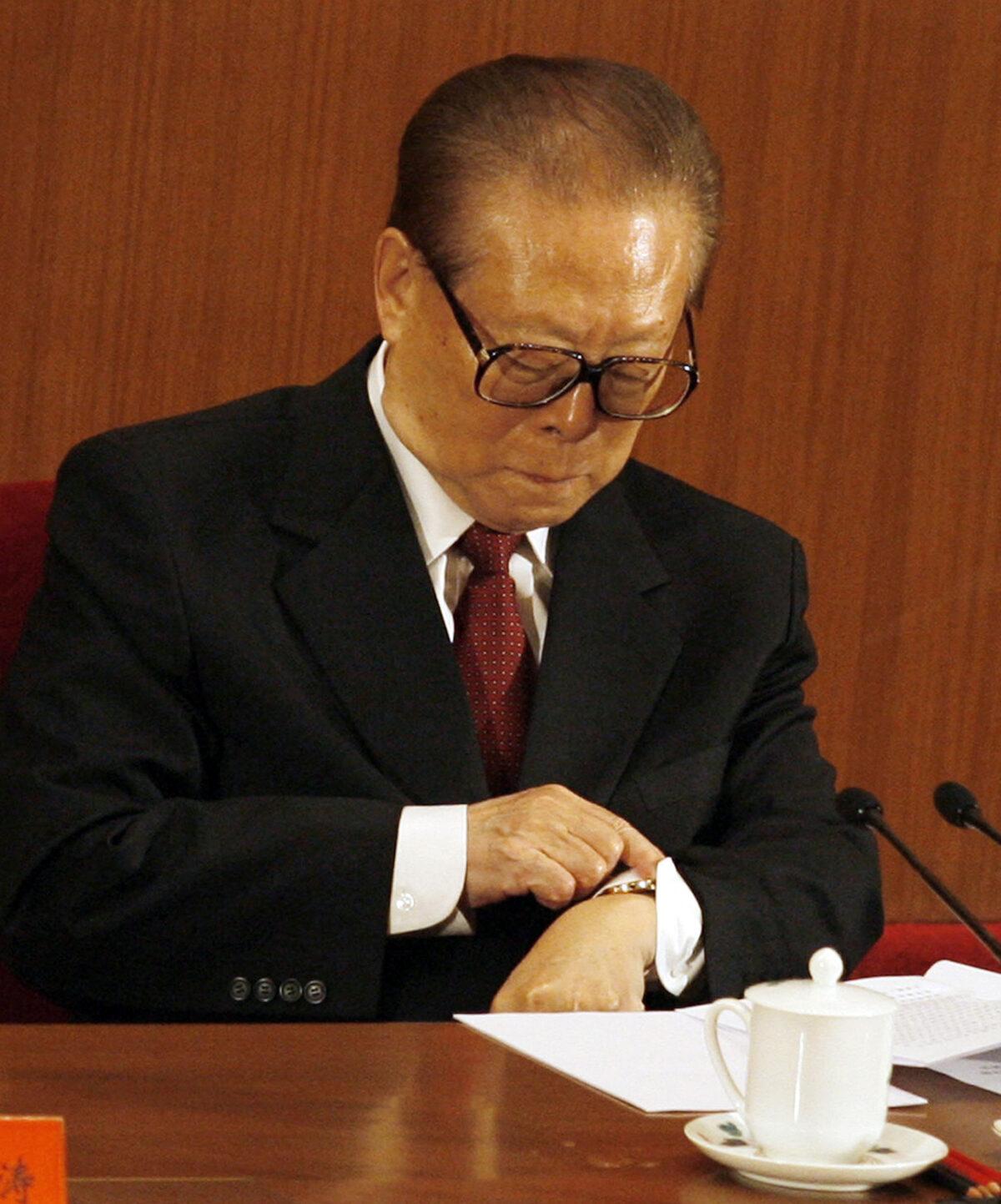 Former Chinese leader Jiang Zemin checks his watch as he listens to President Hu Jintao speak at a ceremony to mark the 80th anniversary of China's People's Liberation Army (PLA) in the Great Hall of the People in Beijing, on Aug. 1, 2007. (Peter Parks/AFP via Getty Images)