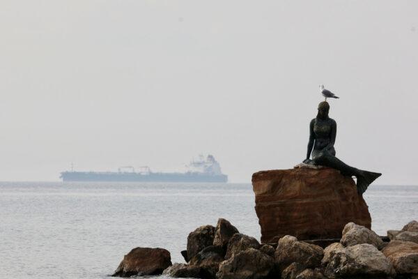 A seagull sits on top of a mermaid statue, with the crude oil tanker Humble Warrior carrying Kazakh oil is in the background at the Dardanelles Anchorage off Sarkoy, near Tekirdag, Turkey, on Dec. 9, 2022. (Yoruk Isik/Reuters)