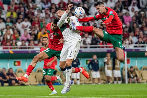 Morocco's Bilal El Khannous, right, fights for the ball with Portugal's Cristiano Ronaldo during the World Cup quarterfinal soccer match between Morocco and Portugal, at Al Thumama Stadium in Doha, Qatar, on Dec. 10, 2022. (Ariel Schalit/AP Photo)