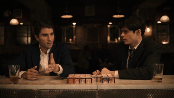 Tucker (Harrison Marx, L) and Ralph (Charlie Ferrera) at a bar play the “Royal Game of Ur,” in "Dragon Eats Eagle." (Prime Video)