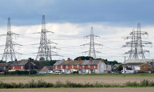 A view of electricity pylons behind houses in Lydd, Kent, England, on Sept. 30, 2022. (Gareth Fuller/PA Media)