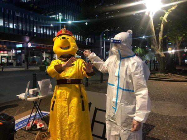 Aaron, who dressed as Winnie-the-Pooh, stood with another protestor who dressed as anti-epidemic personnel in China. (Supplied)