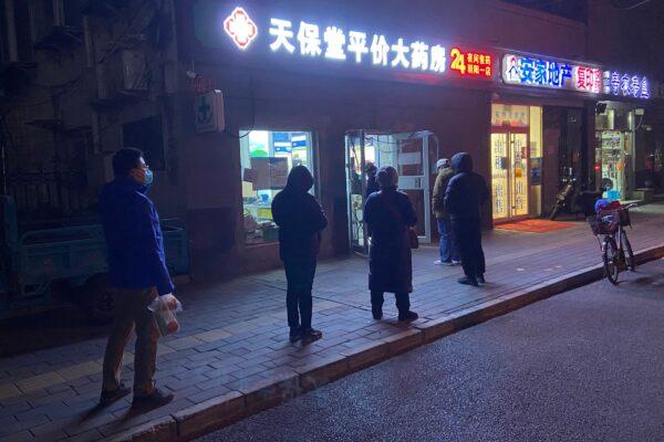 People wait in line to buy medicine at a pharmacy in Beijing on Dec. 12, 2022. (STR/AFP via Getty Images)