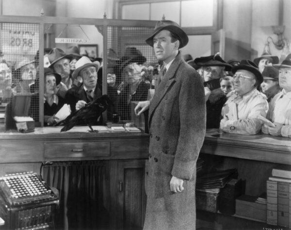 George Bailey (James Stewart) is surrounded by worried loan customers following the stock market crash of 1929 that set off the Great Depression. (MovieStillDB)