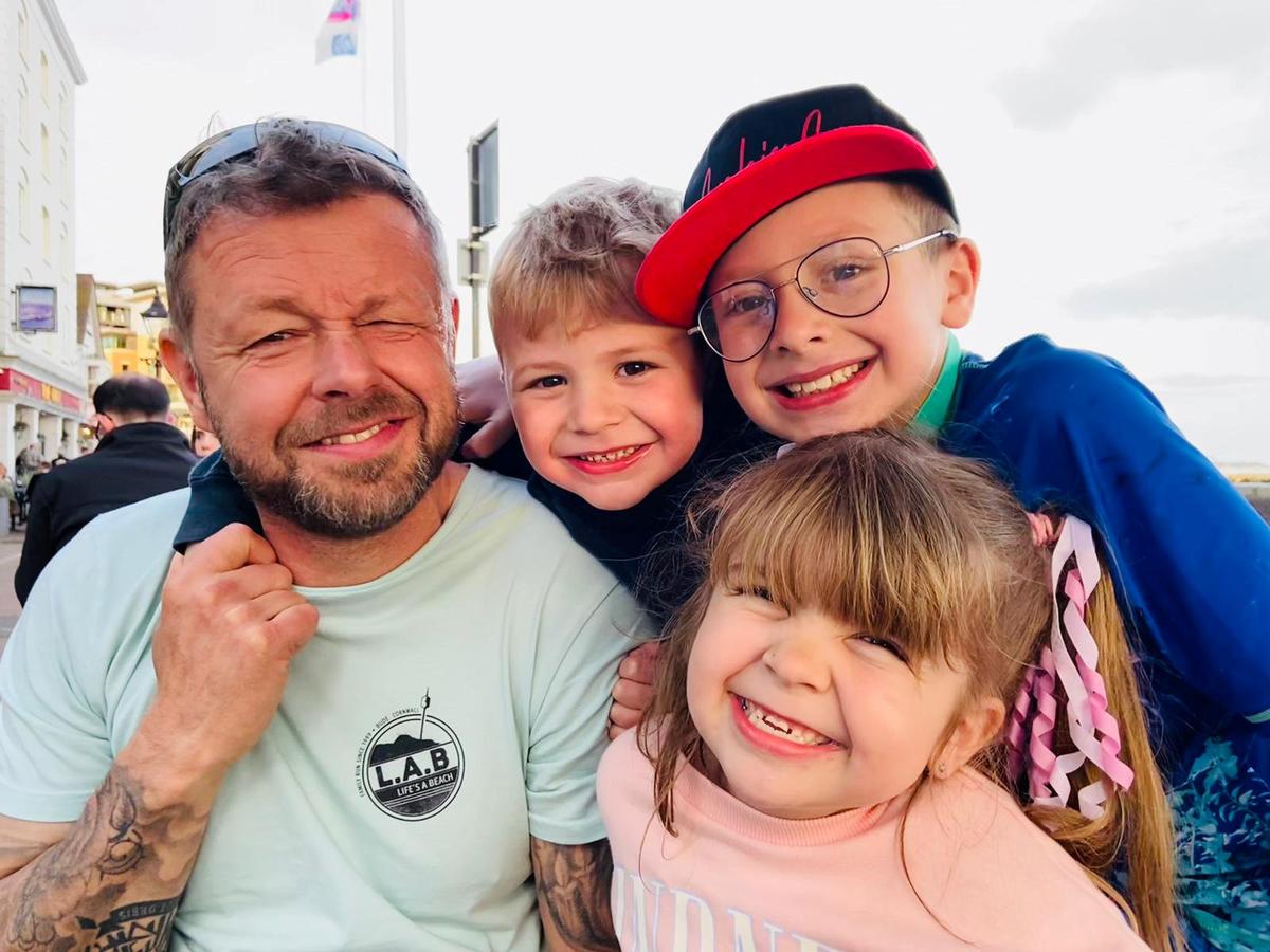 Evie-Mae Geurts with her dad, Martyn Geurts, 49, and her brothers, Archie, 8, and George, 5. (SWNS)