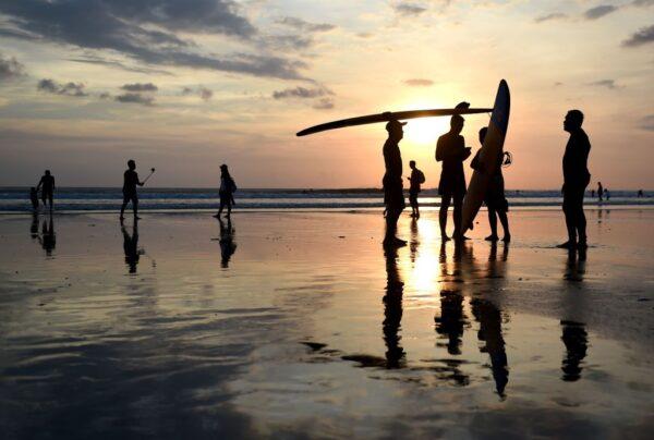 Balinese surfers hold their surfboards during sunset at Kuta beach near Denpasar, on Indonesia's resort island of Bali, on May 13, 2017. (Sonny Tumbelaka/AFP via Getty Images)