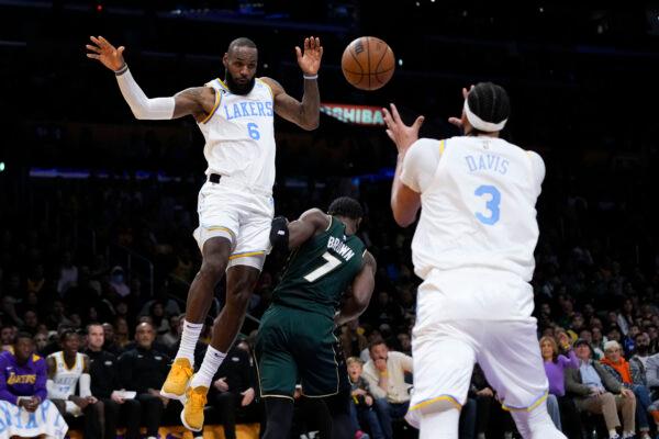Los Angeles Lakers' LeBron James (6) passes the ball to Anthony Davis (3) during first half of an NBA basketball game against the Boston Celtics in Los Angeles on Dec. 13, 2022. (Jae C. Hong/AP Photo)