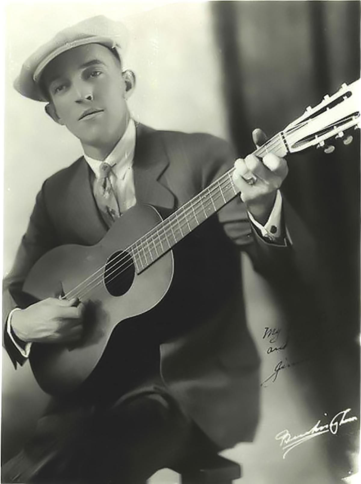 An early professional photo of Jimmie Rodgers posing with his guitar, circa 1921. (Public Domain)