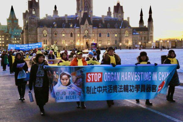 Falun Gong practitioners holding banners march to the Chinese Embassy in Ottawa to celebrate the victory of the passing of Bill S-223 to combat forced organ harvesting, on Dec. 14, 2022. (Jian Ren/The Epoch Times)