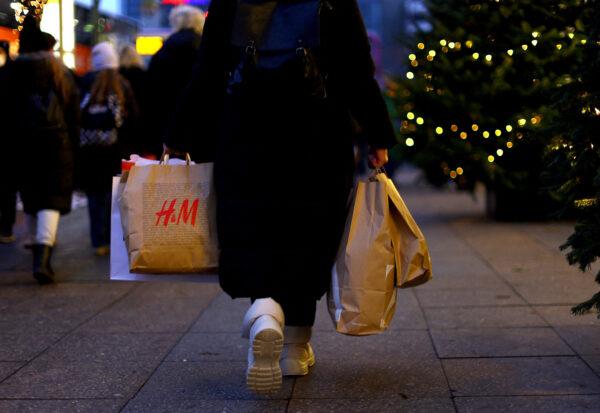 A woman carries a shopping bag branded with the fashion chain H&M on Dec. 3, 2022. (Lisi Niesner/Reuters)