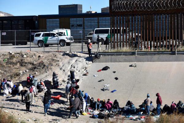 People wait to cross the U.S.–Mexico border from Ciudad Juárez, next to U.S. Border Patrol vehicles in El Paso, Texas, on Dec. 14, 2022. (AP Photo/Christian Chavez)
