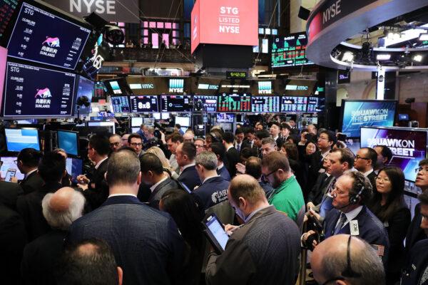 Traders and employees of Sunlands Online Education Group gather on the New York Stock Exchange (NYSE) floor during the Beijing-based firm's initial public offering on March 23, 2018. (Spencer Platt/Getty Images)