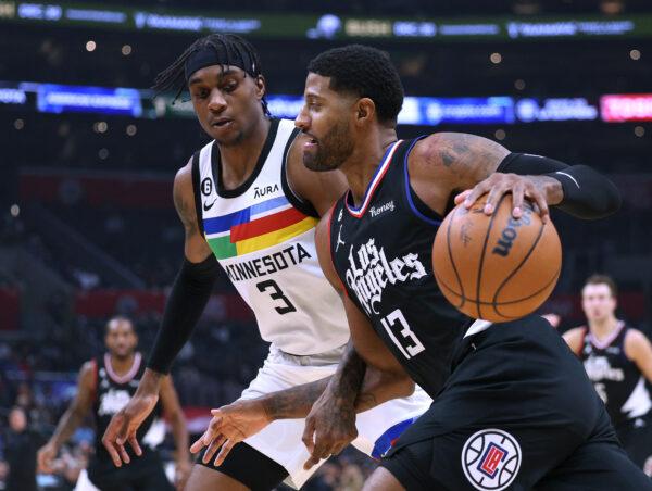 Paul George (13) of the LA Clippers drives to the basket on Jaden McDaniels (3) of the Minnesota Timberwolves during the first half at Crypto.com Arena in Los Angeles, on Dec. 14, 2022. (Harry How/Getty Images)