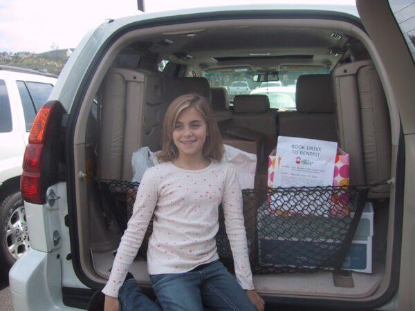 Rachel Glovinsky as a 4th grader delivers a trunk load of books from a book drive she did all by herself. (Courtesy of Charlotte Perry)