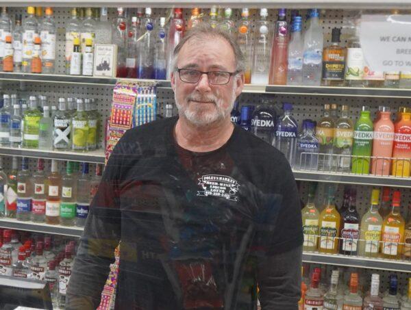 Store clerk Kurt van Conant at Foley's Market in Lexington, Michigan, on Dec. 14, 2022. (Steven Kovac/The Epoch Times)