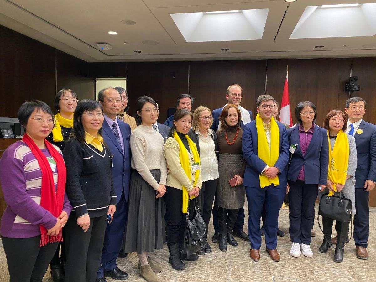 Conservative MPs Garnett Genuis (front, 3rd R) and Arnold Viersen (back, 4th R) poses with Falun Gong adherents as they gathered at a reception held in the Wellington Building on Parliament Hill to celebrate the passing of Bill S-223, on Dec. 14, 2022. (Limin Zhou/The Epoch Times)