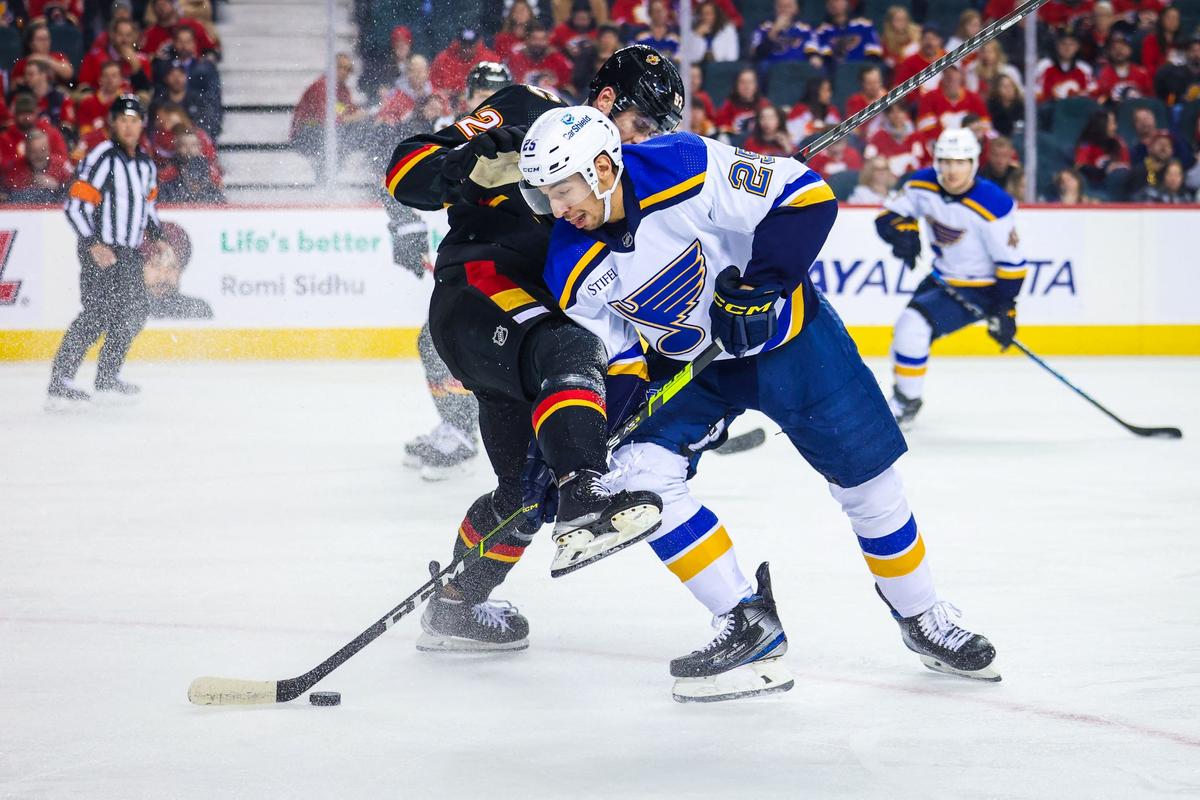 St. Louis Blues center Jordan Kyrou (25) and Calgary Flames defenseman MacKenzie Weegar (52) battle for the puck during the first period at Scotiabank Saddledome in Calgary, Alberta, Canada, on Dec. 16, 2022. (Sergei Belski/USA TODAY Sports via Reuters)