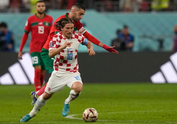 Croatia's Luka Modric, front, dribbles the ball with Morocco's Hakim Ziyech defending during the World Cup third-place playoff soccer match between Croatia and Morocco at Khalifa International Stadium in Doha, Qatar, on Dec. 17, 2022. (Frank Augstein/AP Photo)