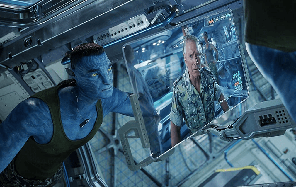 Marine Col. Quaritch (Stephen Lang) in his avatar form (L) and human form on the computer screen, in "Avatar: The Way of Water." (20th Century Studios)