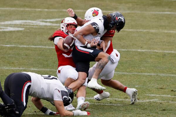 Cincinnati's Evan Prater fumbles as he is tackled by Louisville's Ashton Gillotte during the first quarter of the Fenway Bowl NCAA college football game at Fenway Park in Boston on Dec. 17, 2022. (Winslow Townson/AP Photo)