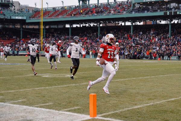 Louisville's Jawhar Jordan, right, runs past Cincinnati's Ja'von Hicks (3) for a touchdown during the first quarter of the Fenway Bowl NCAA college football game at Fenway Park in Boston on Dec. 17, 2022. (Winslow Townson/AP Photo)