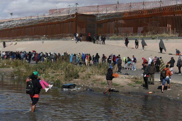 Illegal immigrants walk across the Rio Grande to surrender to U.S. Border Patrol agents in El Paso, Texas, as seen from Ciudad Juarez, Chihuahua state, Mexico, on Dec. 13, 2022. (Herika Martinez/AFP via Getty Images)