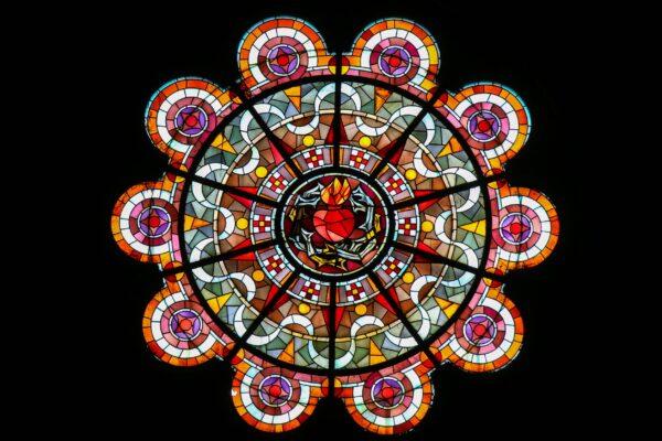 The most important stained-glass window in the basilica symbolizes the Sacred Heart of Christ in the center. The circular window is designed with red circles on the outside, and intricately designed sections that surround the central image. At the center of the window, the sacred heart is depicted in red. (<a href="https://www.shutterstock.com/g/jorisvo">jorisvo</a>/<a href="https://www.shutterstock.com/image-photo/paris-france-february-11-2019-stained-1354316591">Shutterstock</a>)