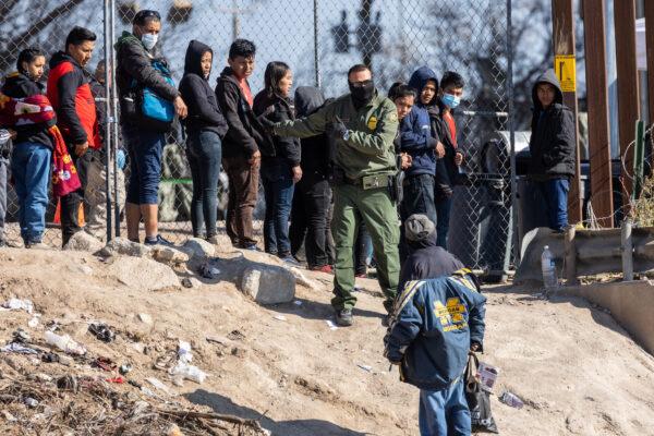  A U.S. Border Patrol agent instructs immigrants who had crossed the Rio Grande into El Paso, Texas, on Dec. 19, 2022 as seen from Ciudad Juarez, Mexico. (John Moore/Getty Images)