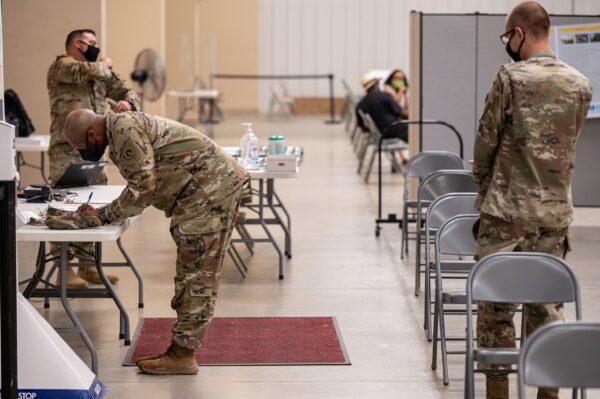 Soldiers file paperwork before being administered COVID-19 vaccines in Fort Knox, Ky., on Sept. 9, 2021. (Jon Cherry/Getty Images)