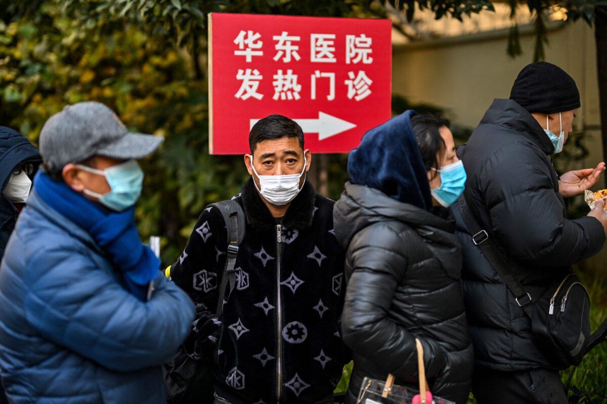 People wait in a line outside a fever clinic at Huadong Hospital in Shanghai on Dec. 19, 2022. (Hector Retamal/AFP via Getty Images)