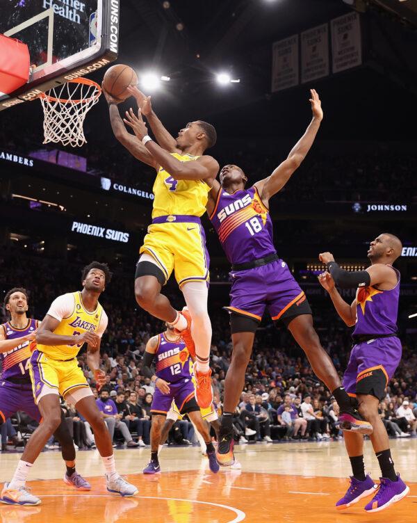 Lonnie Walker IV (4) of the Los Angeles Lakers attempts a shot against Bismack Biyombo (18) of the Phoenix Suns during the second half of the NBA game at Footprint Center in Phoenix on Dec. 19, 2022. (Christian Petersen/Getty Images)