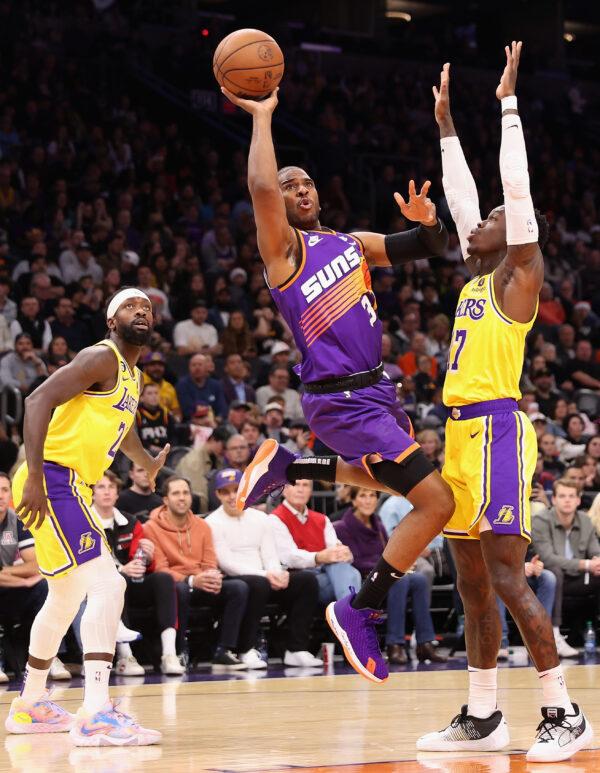 Chris Paul (3) of the Phoenix Suns attempts a shot against Dennis Schroder (17) of the Los Angeles Lakers during the first half of the NBA game at Footprint Center in Phoenix on Dec. 19, 2022. (Christian Petersen/Getty Images)