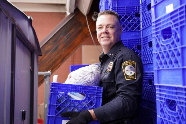 Port Jervis Police Chief William Worden holds a box of turkeys at the Easterseals Project Discovery food pantry in Port Jervis, N.Y., on Dec. 19, 2022. (Cara Ding/The Epoch Times)