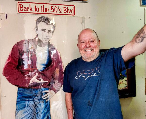 Route 66 Diner owner Jeff Pruett stands next to an iconic picture of James Dean before the lunch crowd arrived on Dec. 7, 2022. (Allan Stein/The Epoch Times)