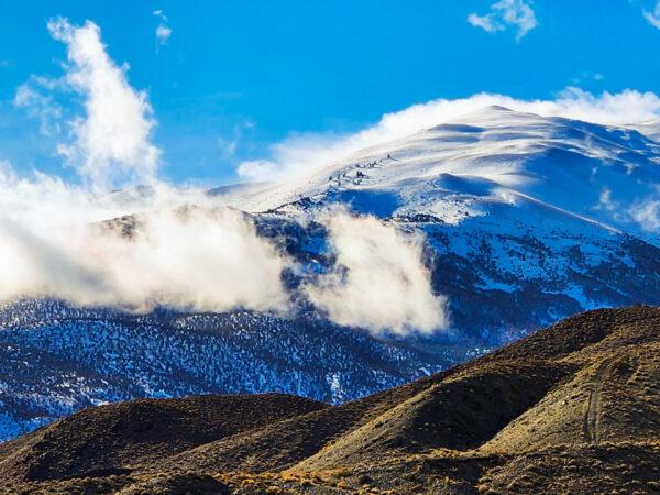 A mountain towers above the clouds outside the town of Walker, Nev., on Dec. 11, 2022. (Allan Stein/The Epoch Times)